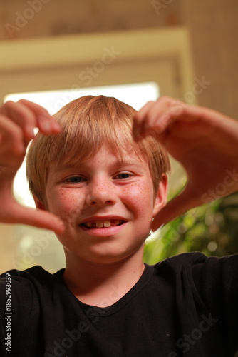 Young boy framing vision with hands, focusing on future