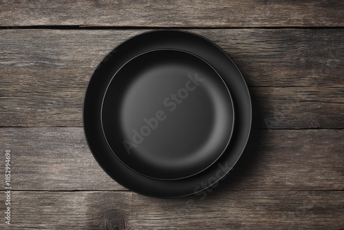 Black plate nested in a larger black plate on weathered wood background