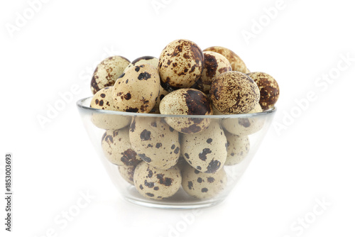 Quail eggs in a glass bowl isolated on white background. Natural patterned farm quail eggs.
