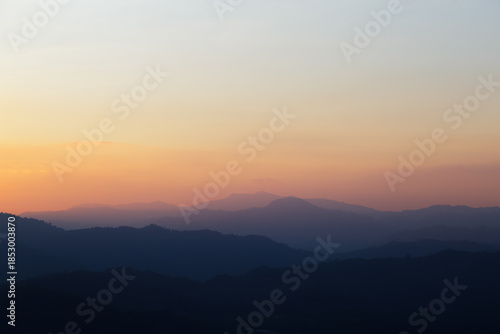 Misty Blue Mountain Range Under Soft Pastel Evening Sky