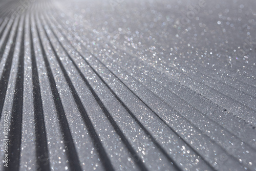 Fresh corduroy groomed snow on ski slope glistening