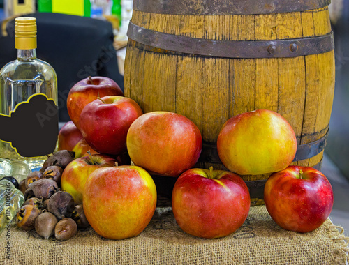 Apples in front of wooden barrel used for making and storing brandy alcohol 