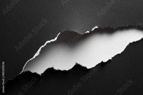 Black paper torn to reveal bright white inside, texture, and abstract background