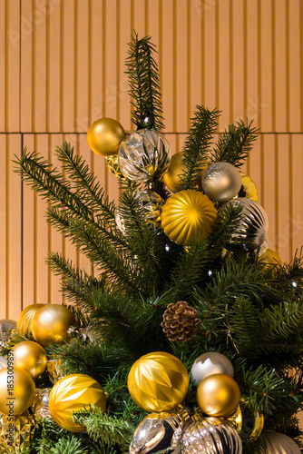 Christmas tree with gold festive ornaments inside room interior