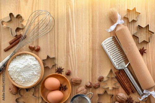 Holiday baking activity with festive decorations and tools for holiday preparation on a wooden background.