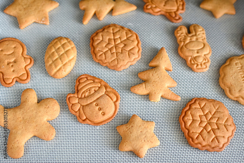 Gingerbread cookies in the shape of festive Christmas ornaments fresh from the modern oven. Making Christmas gingerbread cookies