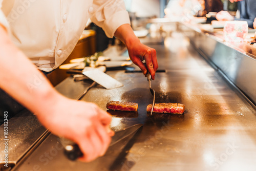 Εκτύπωση καμβά Chef cooks steak on a teppanyaki grill for a delicious meal