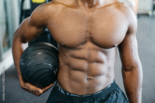 Foto Muscular man holding medicine ball in gym