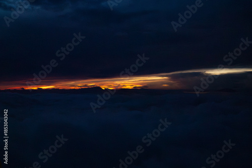 Dawn's Embrace: Witness the dramatic interplay of light and shadow, with the first light of dawn piercing through the clouds, heralding a new day.