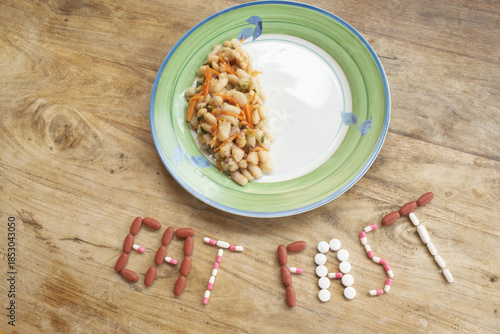 eat fast message with pills and half plate of food on table