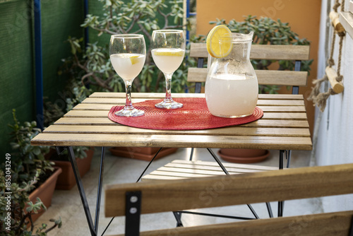 fresh lemonade in pitcher with glasses on an outdoor patio table