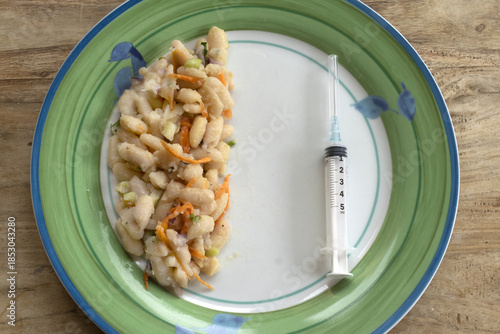 medical weight loss and obesity concept with a syringe and small portion of food in a plate