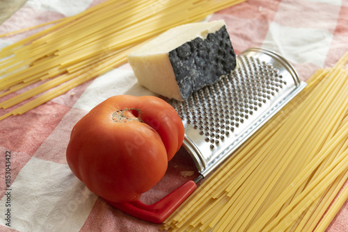 ingredients spaghetti to prepare with  pecorino romano and a big tomato