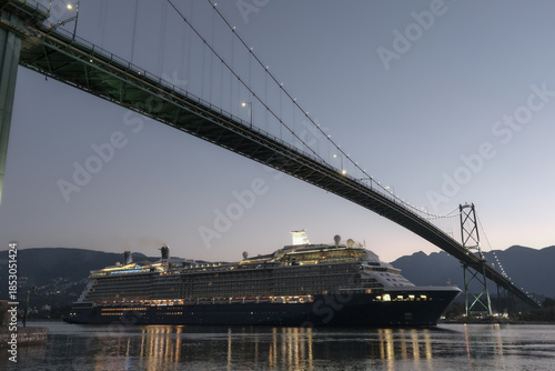 Modern luxury cruiseship cruise ship liner Solstice returning to Vancouver, BC Canada from Alaska cruise during sunrise early morning blue hour harbor landscape marine traffic city skyline silhouette