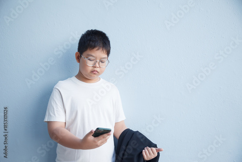 The boy stared at his smartphone with a serious expression.