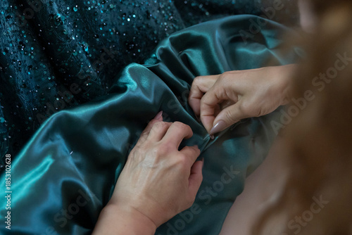 Tailor sewing green evening dress stock photo