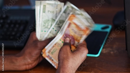 Man counting Indian currency notes for business or financial purpose, representing income and profit calculation.