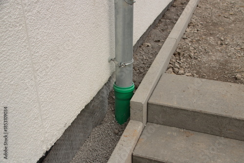 Fallrohr von einer Dachrinne ist an ein Abwasserrohr angeschlossen