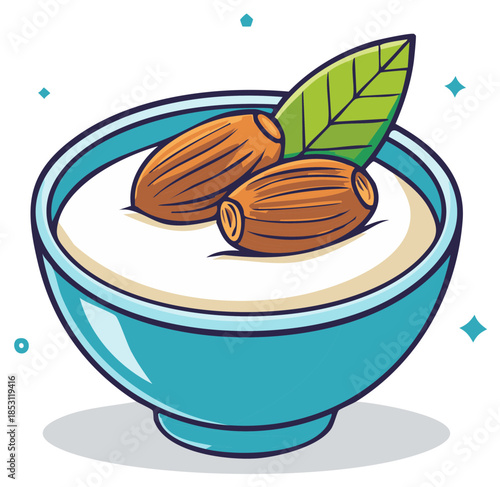 Two almonds floating in creamy white milk in a turquoise bowl with a green leaf garnish