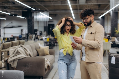 Couple reacting to high prices in furniture store