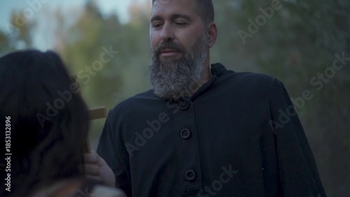 Missionary converts indigenous person to Catholicism by having them kiss the cross
