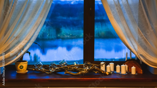Evening window view with decorative branches and candles