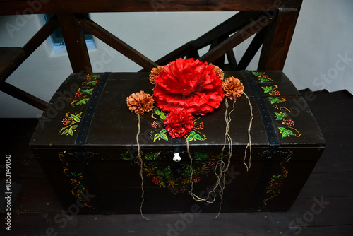 Traditional wooden chest decorated with red paper flowers