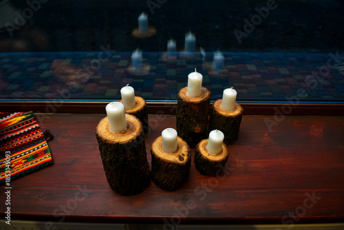 White pillar candles on natural wooden log candle holders