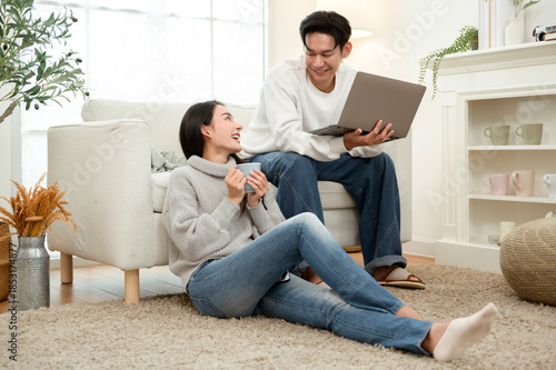 Couple Relaxing at Home in Winter While Using a Laptop and Enjoying Drinks Together