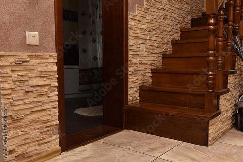 Interior home staircase with wooden steps and open doorway, empty residential hallway, warm domestic interior design, everyday house architecture detail