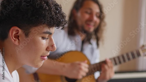 Close up profile of teenager with acne during music lesson with LGBTQ teacher in background
