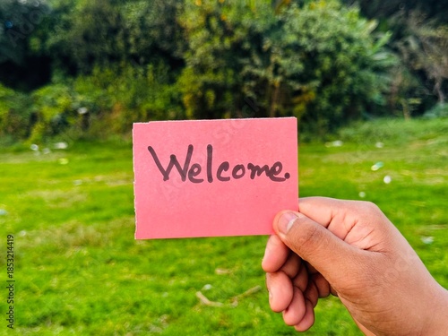 Welcome handwritten sign taken on hand, Most welcome sticky note sign with green background