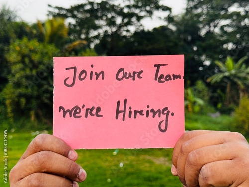 We are hiring trendy card post holding by hand, Join our team recruiting message, Drop your CV sticky note message, Vacancy here image