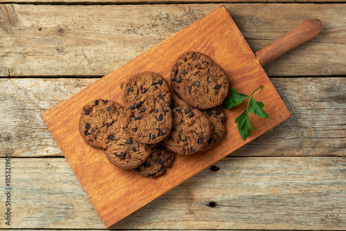Freshly Baked Chocolate Chip Cookies on a Wooden Board With Green Garnish