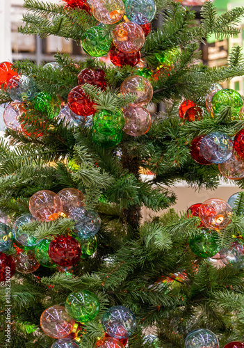 Decorated natural green Christmas tree with colorful festive ornaments