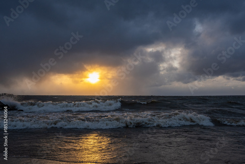 Storm waves against the sunset