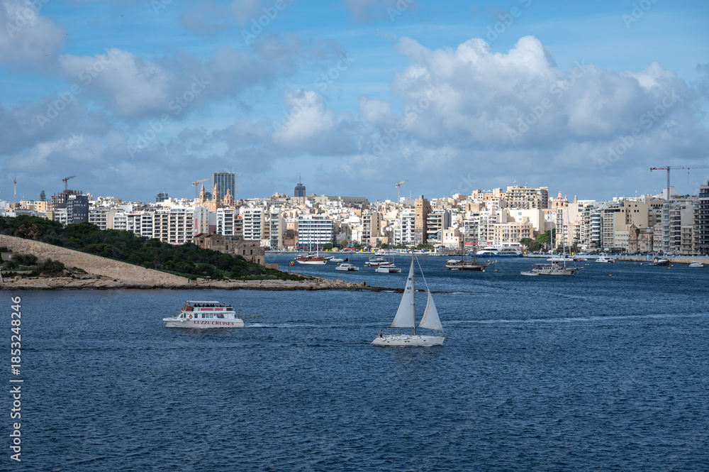 Fototapeta premium View from Valletta over Sliema and Tigné Point, showing the coastal land bridge with modern high-rise buildings and the blue Mediterranean sea Valletta, Malta, 6 DEC 2025.