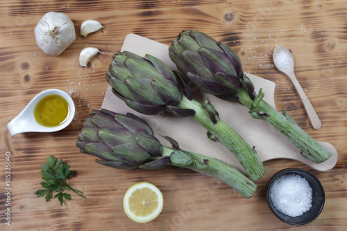 Raw Artichokes and Ingredients Flat Lay on Rustic Wooden Table
