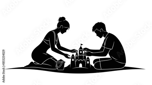 Silhouette of a couple building a sandcastle at the beach