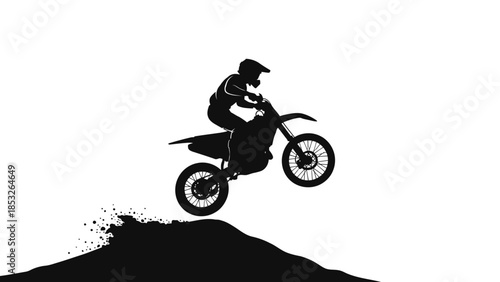 Silhouette of a motocross rider performing a jump on a dirt bike