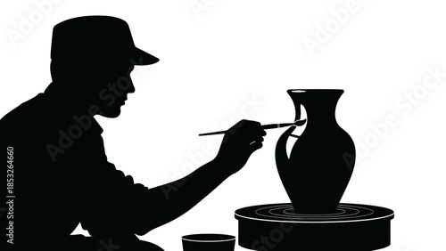 Silhouetted potter carefully shaping a vase on a rotating pottery wheel