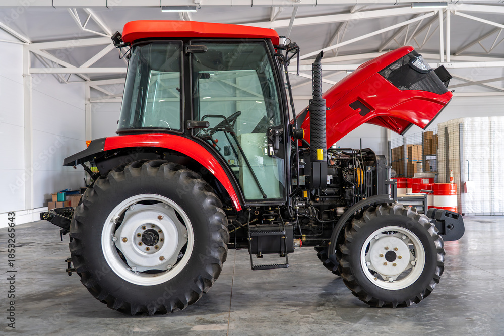 Obraz premium Modern red agricultural tractor with open hood in service garage, farming machinery inspection, agricultural vehicle maintenance, heavy equipment repair, rural technology concept.