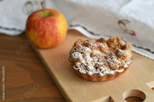 Apple crumble on wooden board with apple