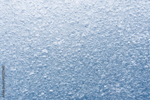 Blue ice texture background showing air bubbles frozen in a glacier