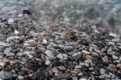 Принти на полотні Long exposure of moving water flowing over smooth coastal pebbles