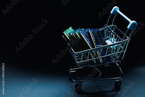 Laptop ddr memory modules in toy shopping cart on black background
