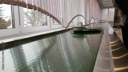 Dirty kitchen trays with leftovers move on a motorized conveyor belt toward the industrial washing area in a busy catering canteen, showcasing high-volume commercial dishwashing processes in 4k.