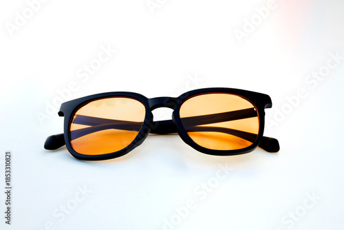 Εκτύπωση καμβά Symmetrical view of amber tinted glasses with black frame, designed to filter blue light and reduce strain from extended digital use