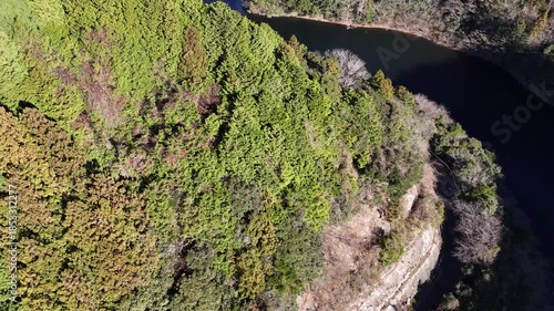 日本のドローン映像　冬の晴れた日に山の上から上昇しながら湖を空撮
