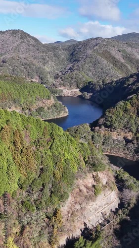 日本のドローン映像　冬の晴れた日に山を越えてダム湖を空撮
